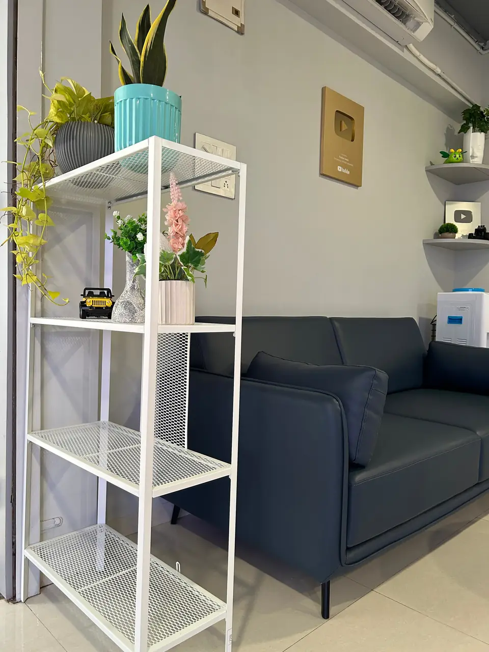 Lounge at TubePod Media with a navy sofa and white shelves