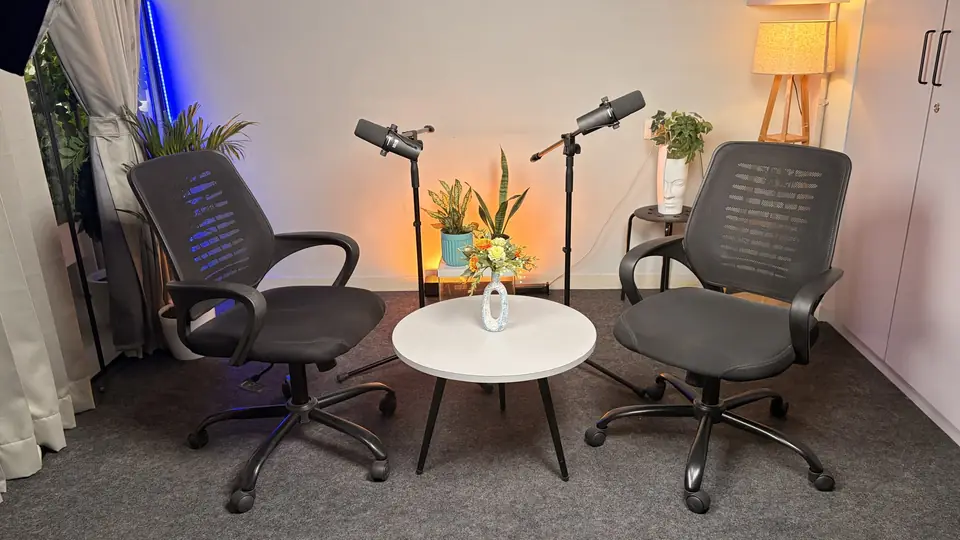 Round-table podcast setup with two chairs and microphones